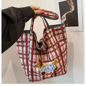 Detail of red and blue checkered canvas tote bag with cute dog embroidery decoration