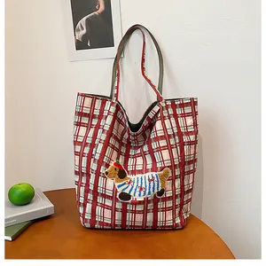 Detail of red and green plaid tote bag with cute dachshund puppy embroidery and double handles