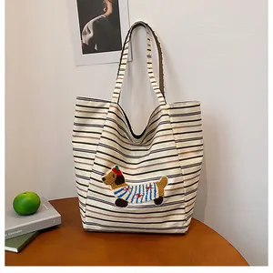 Detailed close-up of a striped canvas tote bag featuring a cute dachshund embroidery pattern