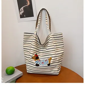 Close-up of cute 3D puppy embroidery with red beret on a striped canvas tote bag