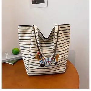 Detail of cute dachshund embroidery on a striped canvas tote bag on a wooden table