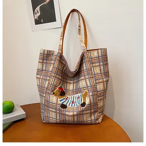 Close-up of checkered canvas tote bag with cute dachshund patch and soft texture