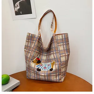 Detail of checkered tote bag featuring a cute dachshund embroidery and thick canvas texture