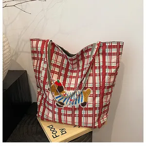 Detail shot of red checkered tote bag featuring a cute 3D puppy embroidery patch