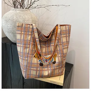 Detail of colorful plaid canvas tote bag with 3D dachshund embroidery on wood surface