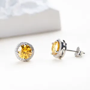 Macro-opname van oorknopjes met een gele ronde steen en zilveren pavé zetting details