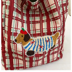 Close-up of a plaid tote bag featuring a 3D dachshund dog embroidery patch