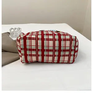 Close-up of red and green plaid canvas tote bag fabric with thick woven texture detail