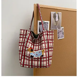 Close-up of vintage plaid tote bag with cute dachshund plush embroidery details