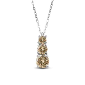Macro view of three champagne moissanite stones in graduated sizes on a silver pendant