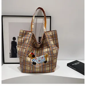Close-up of cute dog embroidery patch and retro yellow blue plaid canvas tote bag fabric