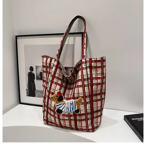 Detailed close-up of colorful checkered canvas tote bag with cute dog embroidery patch