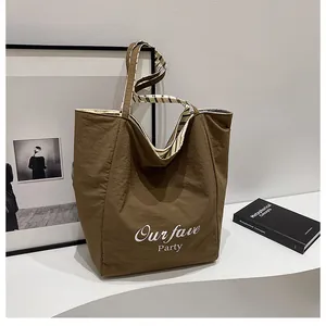Detail of dark brown crinkled tote bag with Our fave Party print and striped lining