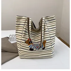 Detailed view of corduroy tote bag with striped pattern and cute dachshund embroidery