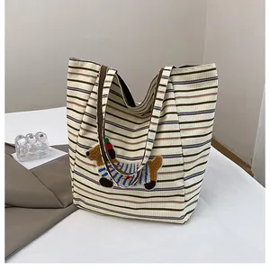 Close-up of cute cartoon dachshund patch on a striped corduroy tote bag fabric