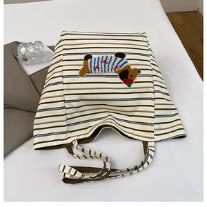 Detail view of striped canvas tote with 3D puppy plush embroidery and dual handles