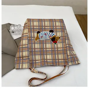 Close-up of cute cartoon bear embroidery on yellow plaid canvas tote bag
