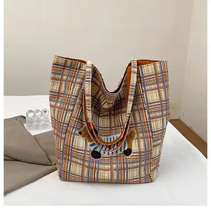 Close-up of vintage plaid tote bag featuring a cute cartoon dachshund embroidery detail