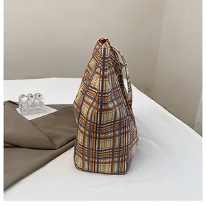 Detailed side view of large capacity reversible plaid canvas tote bag with woven texture
