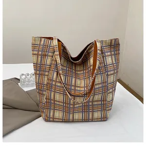 Detail of checkered canvas tote bag showing high-capacity design and orange blue patterns