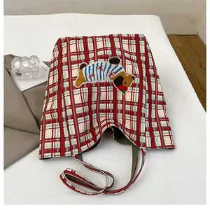 Detail of red checkered canvas tote with cute dog embroidery and green inner lining