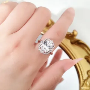 Close-up of 4ct radiant cut moissanite ring with halo setting on finger