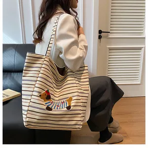 Close-up of canvas tote bag featuring a cute dachshund embroidery and striped pattern