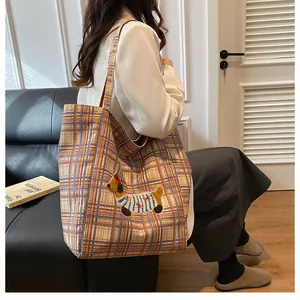 Detail of cute dachshund embroidery on a large capacity yellow checkered canvas tote bag