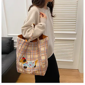 Detailed side view of a large plaid tote bag featuring a cute dog embroidery on canvas