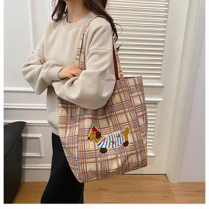 Detail view of large check tote bag with cute cartoon dog embroidery and canvas strap