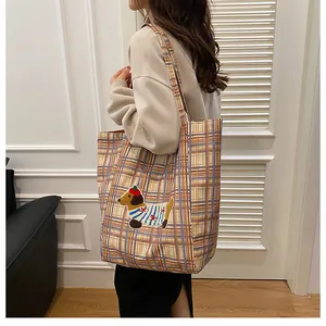 Detail of yellow checkered tote bag featuring a cute dachshund puppy embroidery patch