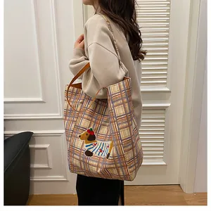 Detail of checkered canvas tote bag with cute dachshund embroidery and leather strap