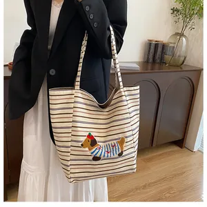 Close-up of cute cartoon puppy patch embroidery on large striped canvas tote bag