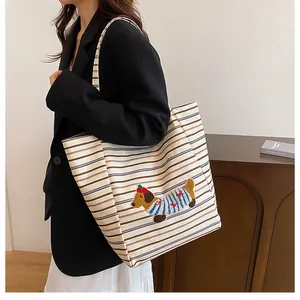 Detail of large canvas tote bag with striped pattern and cute dachshund embroidery