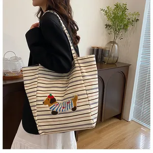 Detail of colorful striped canvas tote bag featuring cute cartoon dog embroidery