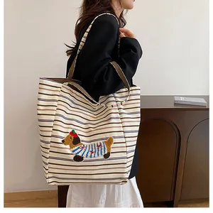Detail of striped canvas tote bag featuring cute dachshund embroidery and large capacity