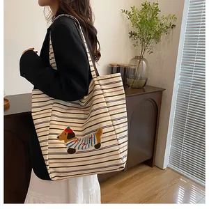 Close-up of a striped canvas tote bag featuring a cute dachshund embroidery patch