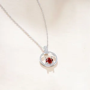 Macro di un ciondolo in argento S925 con moissanite rossa e cristalli pavé luccicanti