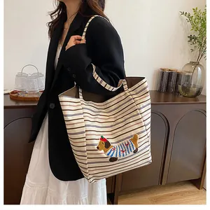 Detailed close-up of large canvas tote bag with brown stripes and cute dachshund embroidery