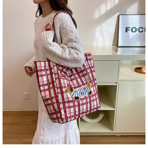 Close-up of red checkered canvas tote bag featuring cute dachshund dog embroidery detail
