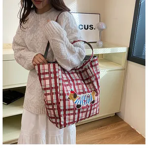 Detail of red checkered canvas tote bag with 3D puppy embroidery shown on model