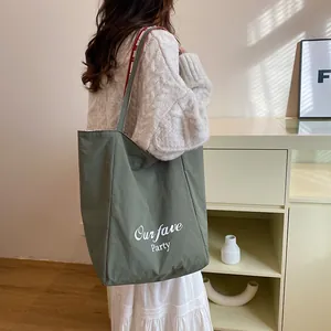 Army green large canvas tote bag with Our fave Party print worn by a model