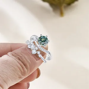 Detail of silver S925 ring set with blue-green moissanite and pavé diamond band