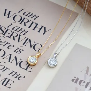 Classic round moissanite pendant necklace in silver and gold finishes on a minimalist card