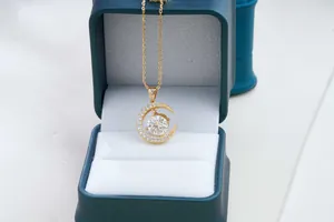 Nahaufnahme eines Mondsichel-Goldanhängers mit Moissanit in einer Samt-Geschenkbox