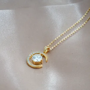 Makroaufnahme von Goldanhänger mit Mondsichel, Moissanit und Diamantenbesatz