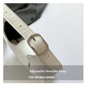 Detailed macro view of the white shoulder bag featuring an adjustable silver metal buckle