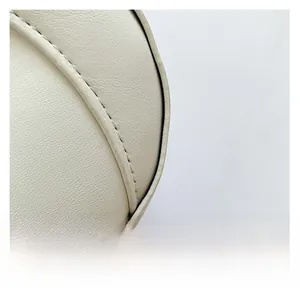 Close-up of off-white leather underarm bag showing detailed litchi grain texture