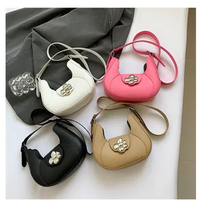 Flat lay of four leather hobo bags in white, pink, black, and khaki with floral buckles