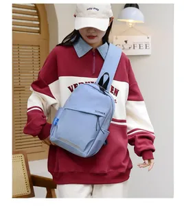 Détail du sac bandoulière en nylon bleu clair avec bande réfléchissante et poche latérale